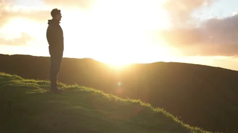 Man watching sundown, camera panned to background Stock Footage 59188974