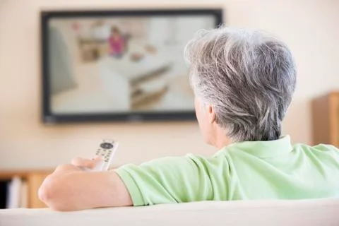 Man watching television using remote control Stock Photos