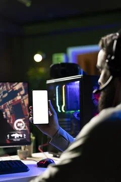 Man watching tutorial on mockup phone while gaming Stock Photos