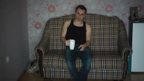 Man watching TV and drinking tea Vidéo 87398534
