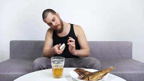 Man watching TV and drinking beer with fish.Loneliness and alcoholism. Stock Footage 122755491