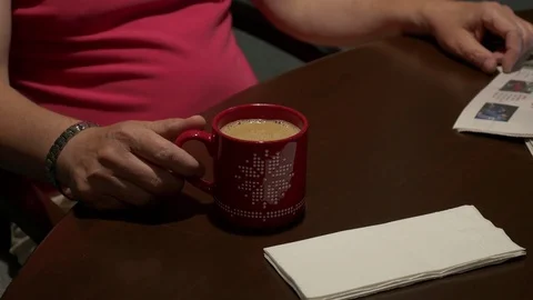 A man watching TV, drinking coffee in a club (close up on cup). 動画素材 77174900