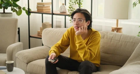 Man watching tv sitting on sofa Stock Footage 145293632