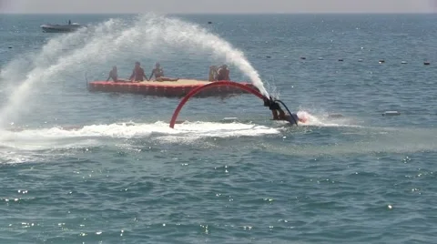Man on Water Jet Pack Flyboard near Sea Beach Resort and people crowd Stock Footage 40322524