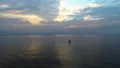 The man in the water on the sunrise background. quadrocopter shot 4k or 4k+ Resolution