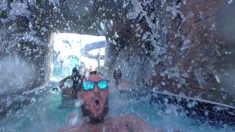 Man on Waterpark Lazy River Floaty Under Waterfall Vidéo 285552811