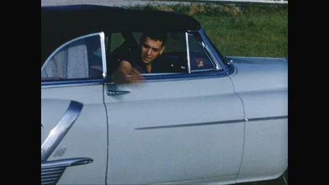 Man waves and drives away in white Cadillac 1950s, vintage film Stock Footage 125838036
