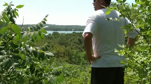 Man Waves to Come Look at View Video stock 12599030