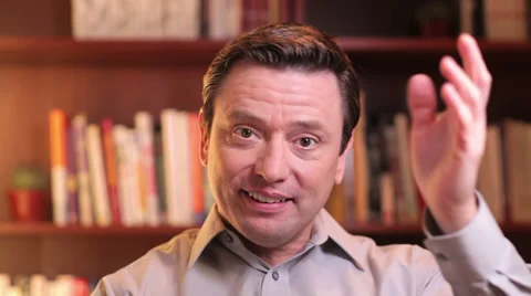 A man waves his hand and laugh while talking over a video chat. Close up shot Stock Footage 33841561