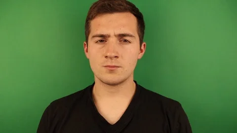 A man waves his head in different directions on a green background, the concept Vídeo Stock 118854730