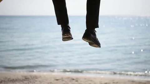 A man waves his legs on the beach Stock Footage 74589328