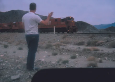 A man waves to a train Stock Photos