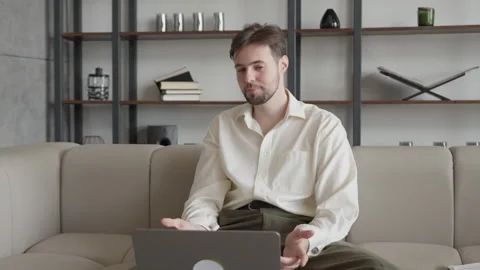 Man Waving And Smiling During Video Call, Sitting On Couch And Chatting Online Stock Footage 306699058