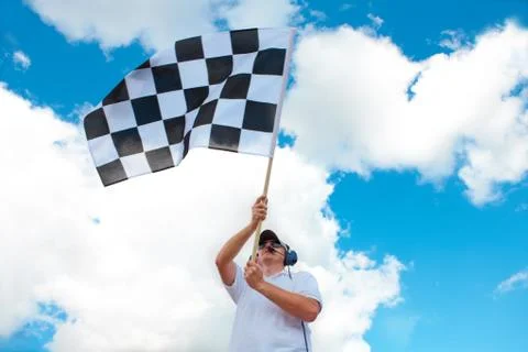 Man waving a checkered flag on a raceway Stock Photos