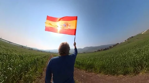 A man waving the flag of Spain in circles in a green field 스톡 동영상 234162153