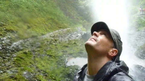 Man Waving Hand Under Waterfall Stock Footage 874758