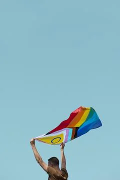 Man waving a progress pride flag in the air Stock Photos