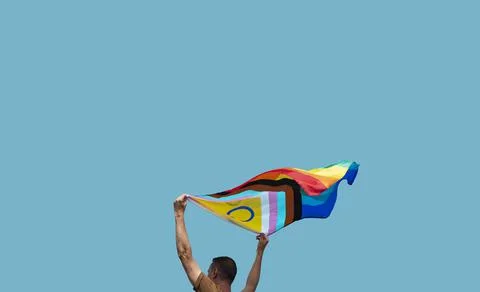 Man is waving a progress pride flag outdoors Stock Photos