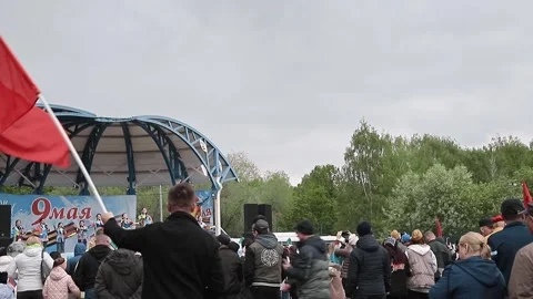 Man waving red Soviet flag with hammer and sickle at Victory Day Video stock 332474103