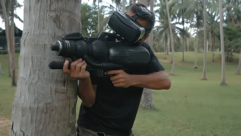 Man with weapon playing virtual reality game in the jungle, drone shot 스톡 동영상 89505889