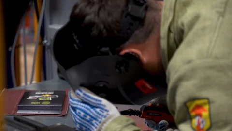 Man wear work clothes, protective gloves use welding tool to weld metal details  Stock Footage 126356389