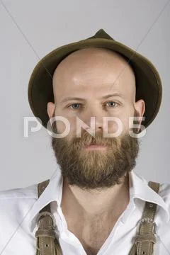 A man wearing an alpine hat and lederhosen Stock Photos