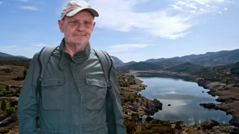 Man Wearing Backpack Exploring Scenic Lake in a Beautiful Mountain Landscape Stock Footage 316843257