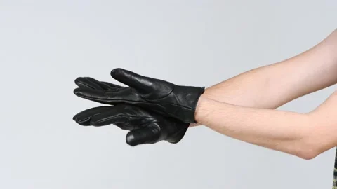 A man wearing black gloves claps his hands with the back of his hand. Stock Footage 168482175