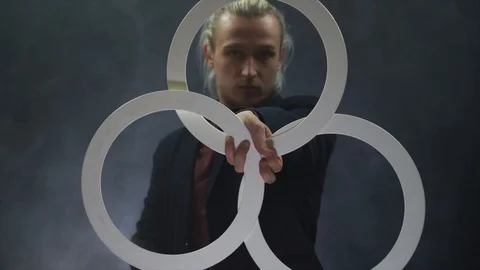 Man wearing a black manipulating with white rings. concentration and Attention Stock Footage 127389635