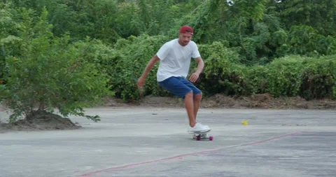 Man wearing blue shorts practicing turn on surf skateboard in outdoor park. Stock Footage 164998734