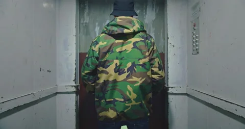 Man wearing camouflage jacket inside industrial elevator cabine going up. Urban Stock-Footage 132098750