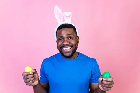 Man wearing cute easter bunny ears in studio pink wall background Stock Photos