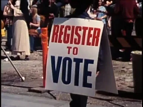 Man wearing double sided Register to Vote sign during protest, 1970s Stock Footage 64630034