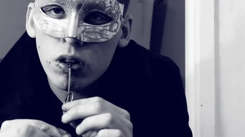 Man wearing eye mask pulls bloody razor blade from mouth. Stock Footage 79864648