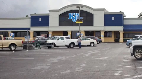 Man wearing face mask in the grocery store parking lot Stock Footage 142974053