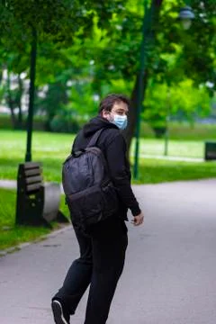 Man wearing face mask walking alone in the park Stock Photos