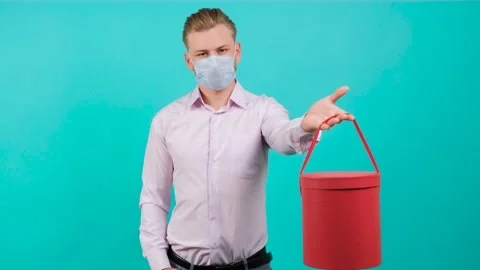 Man wearing face mask while giving a box and standing in the studio. Stock Footage 143589524