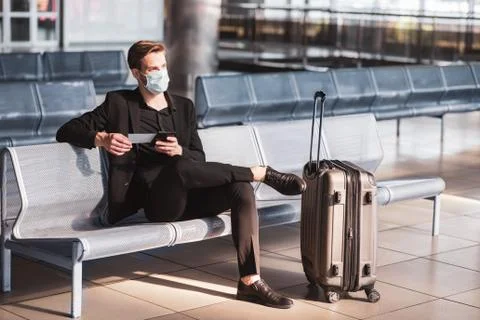 Man wearing a face mask while staying in the airport Stock Photos