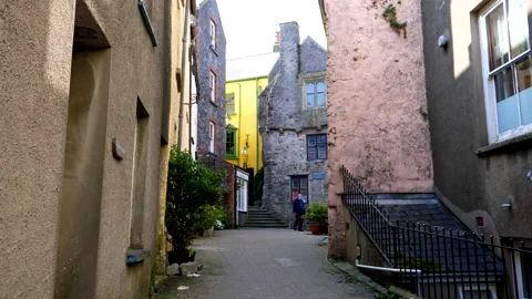 Man wearing face shield walking between houses 動画素材 145290820