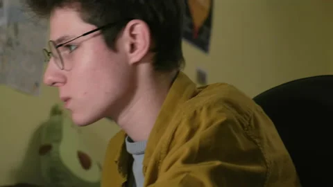 A man wearing glasses. He sits at the computer. Stock Footage 151786331