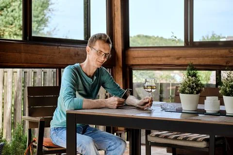 Man wearing glasses using phone, looking at smartphone screen and holding gla Foto stock