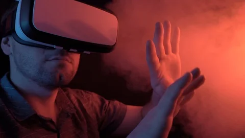 A man wearing glasses of virtual reality is sitting on a chair stretching out Stock Footage 115089608