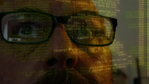 Man wearing glasses watching lines of code and data scanning displayed on front Stock Footage 342076153