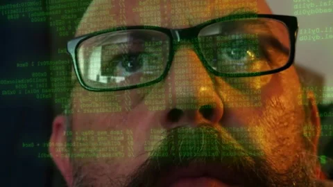Man wearing glasses watching lines of code and data threat scanning displayed Stock Footage 342076188