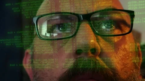 Man wearing glasses watching lines of programming code scanning displayed on Stock Footage 342179189