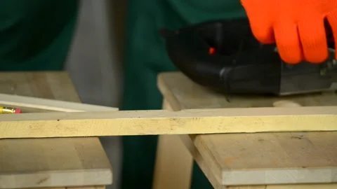 A man wearing gloves makes a mark on the board with a pencil and a tape measure. Stock Footage 128871839