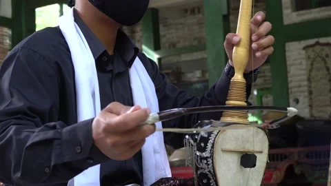 A man wearing a green mask while playing fiddle. Indonesia Stock Footage 145885451