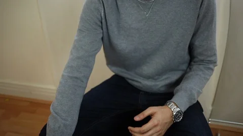 Man wearing a grey sweater gesturing dramatically with his hands as he speaks Stock Footage 107619592
