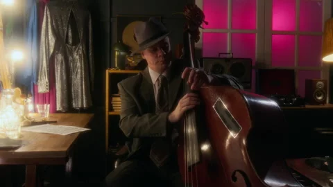 Man Wearing Hat and Looking at Camera Posing With Upright Bass Stock Footage 312238412