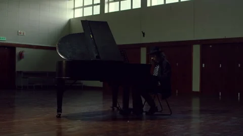 Man wearing a hat and playing a piano in a hall Stock Footage 279803256